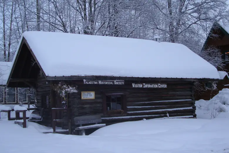 Cabana de madeira coberta de neve em Talkeetna, no inverno do Alasca
