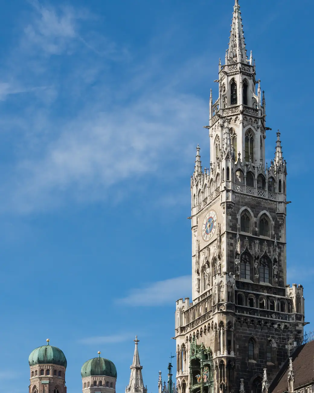Torre gótica da Nova Prefeitura de Munique com as cúpulas da Frauenkirche ao fundo