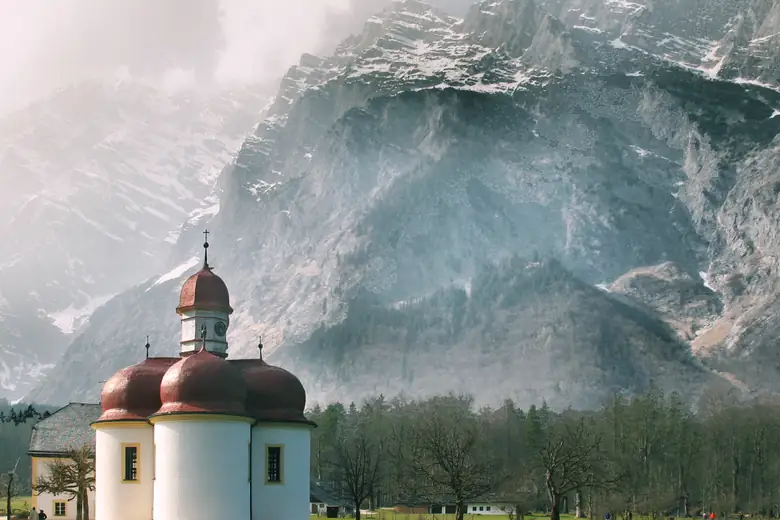 Capela de São Bartolomeu à beira do lago Königssee, cercada pelos paredões dos Alpes