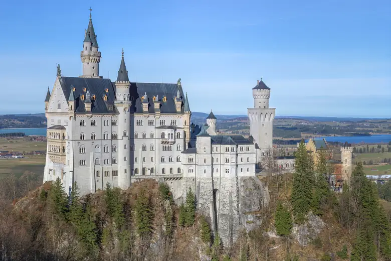 Castelo de Neuschwanstein visto de frente, com os Alpes ao redor