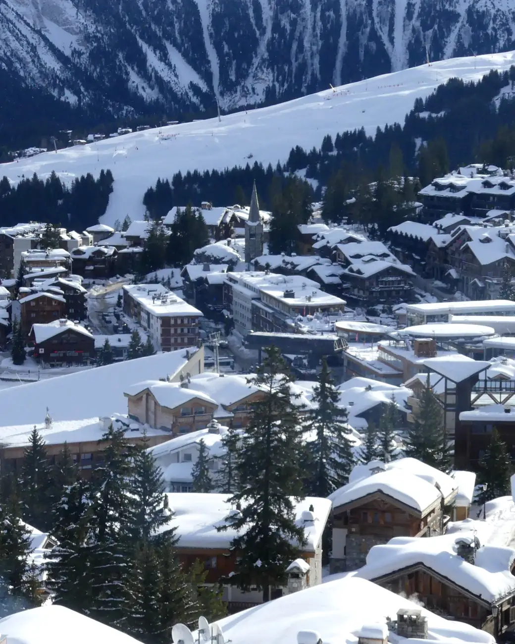 Vilarejo de Courchevel iluminado ao anoitecer sob a neve