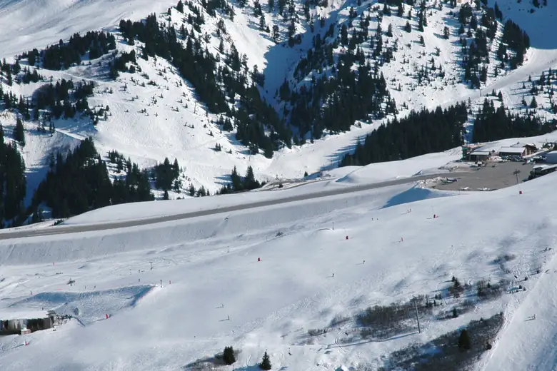 Pista inclinada do altiporto de Courchevel em meio à neve