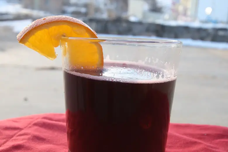 Copo de vin chaud com laranja servido na neve