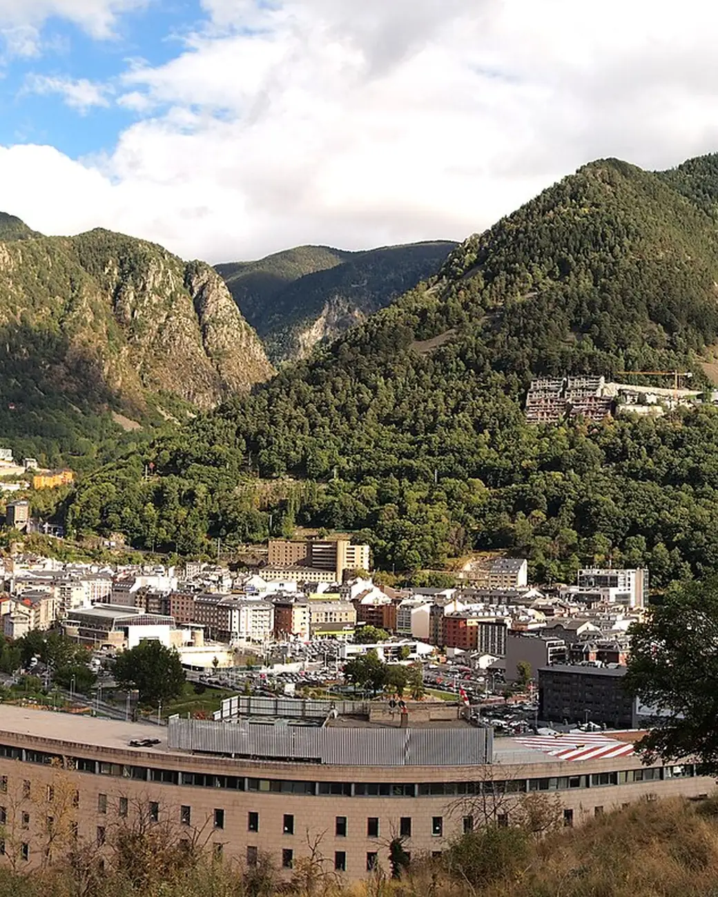 Vista de Andorra la Vella com a torre de vidro de Caldea entre montanhas