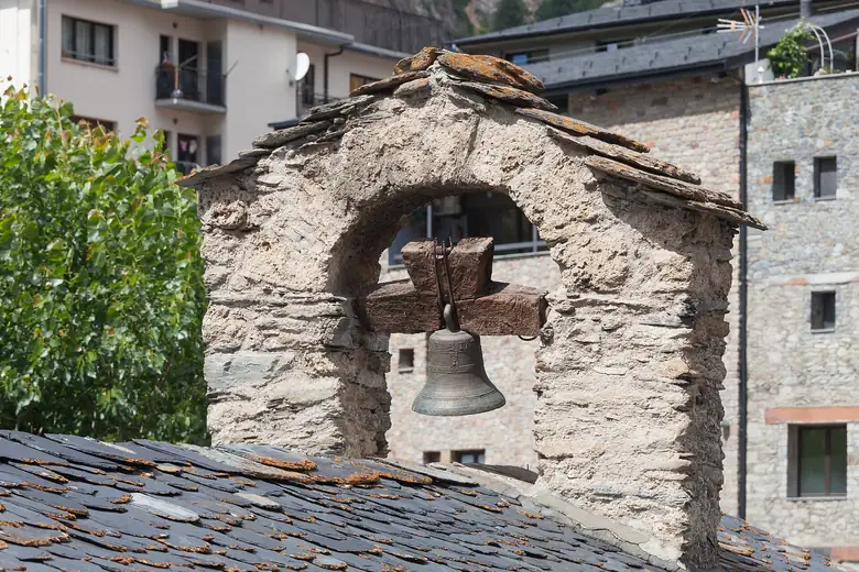 Campanário de pedra com sino e telhado de ardósia num vilarejo de Andorra
