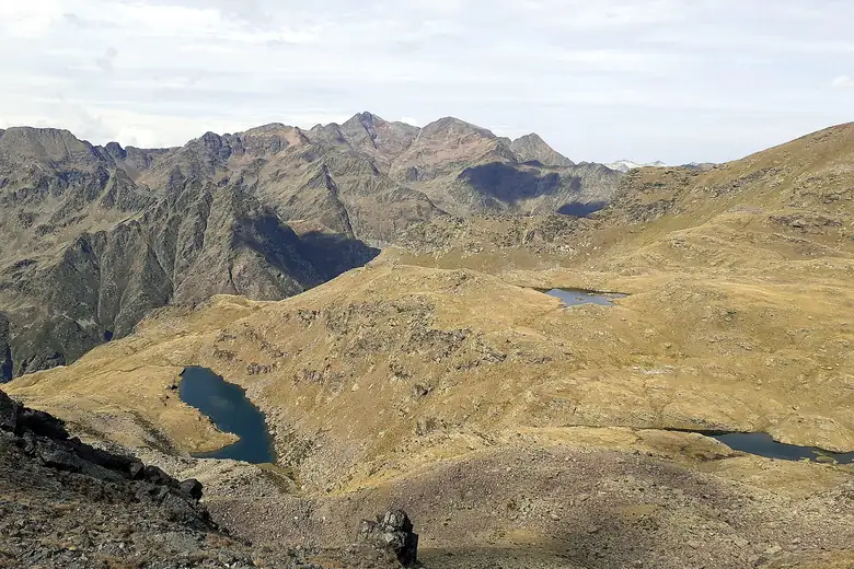 Lago de altitude azul entre picos dos Pireneus em Andorra