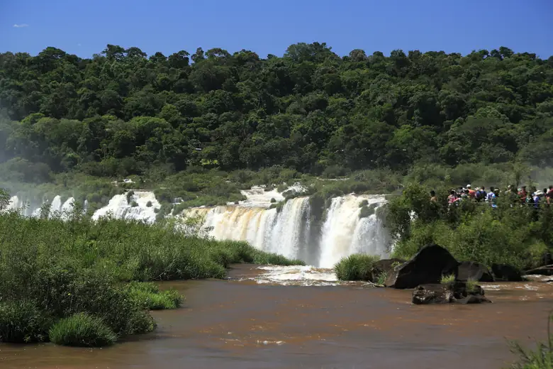 Visitantes nas passarelas do circuito argentino diante de uma linha de quedas do Iguazú