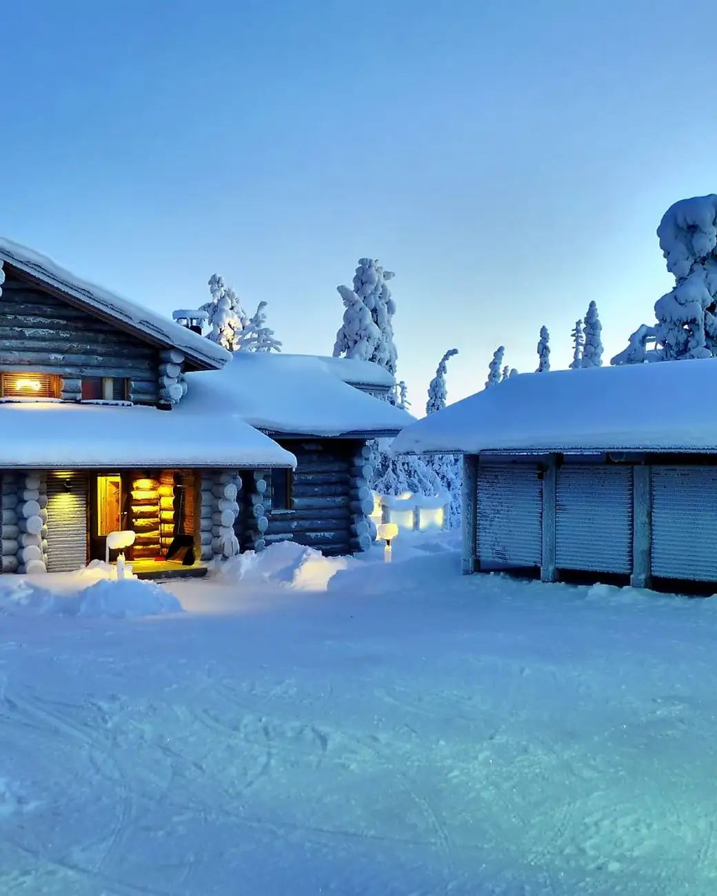 Iglus de vidro iluminados na neve da Lapônia finlandesa ao anoitecer