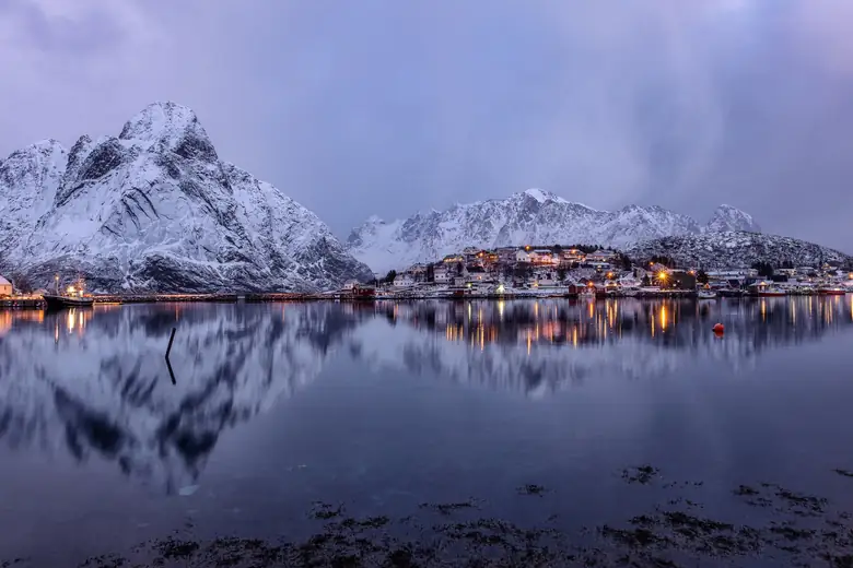Montanhas nevadas dos Alpes de Lyngen refletidas no fiorde