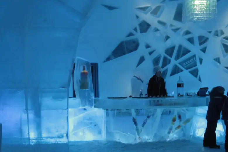 Escultura e mobiliário de gelo num salão do Icehotel sueco