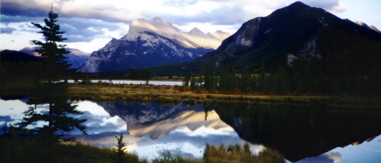 Entardecer dourado sobre lago e montanhas nas Rochosas canadenses
