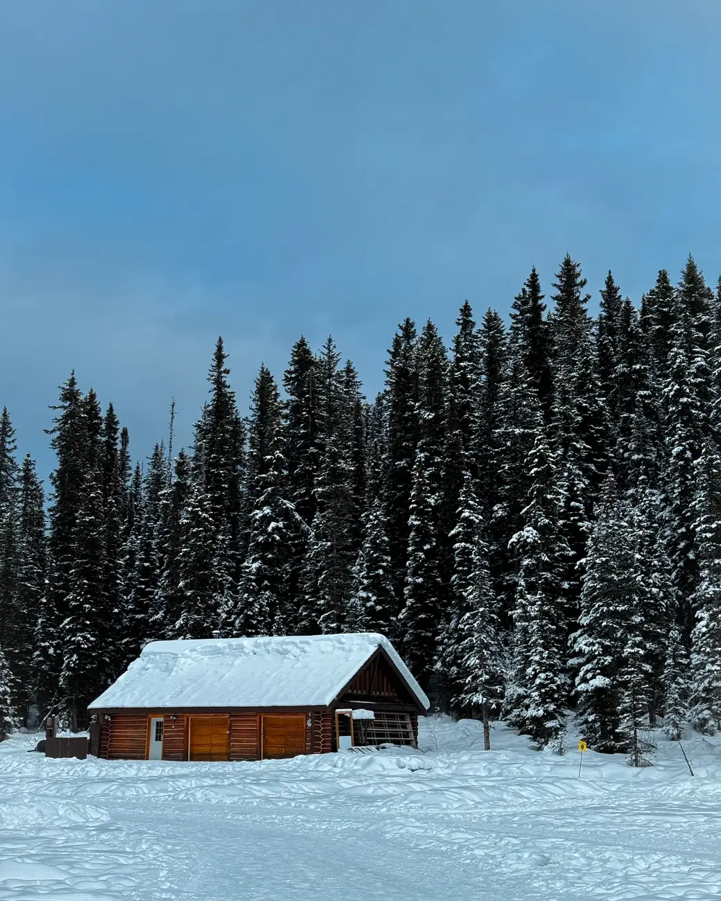 Cabana de madeira na floresta nevada, no inverno das Rochosas canadenses