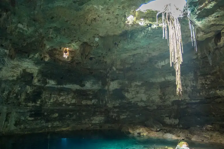 Águas cristalinas e feixes de luz dentro de um cenote