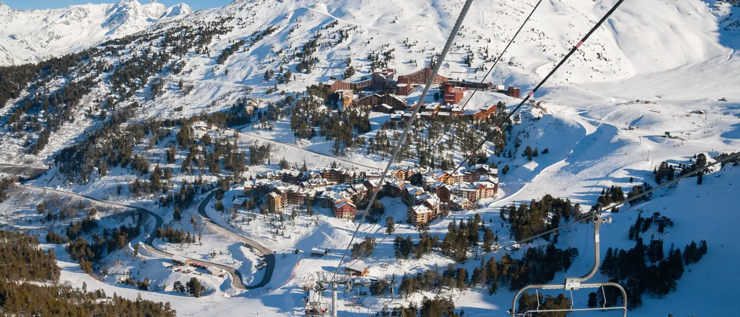 Cadeiras do teleférico sobre a floresta nevada em Les Arcs