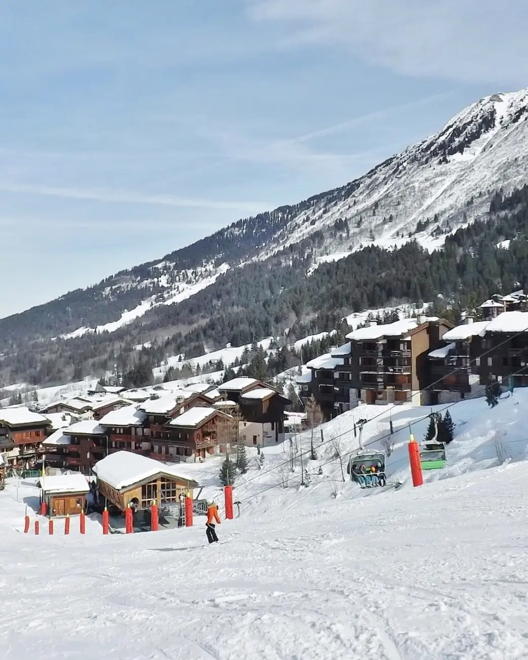 Vila alpina francesa aos pés das pistas, com montanhas nevadas