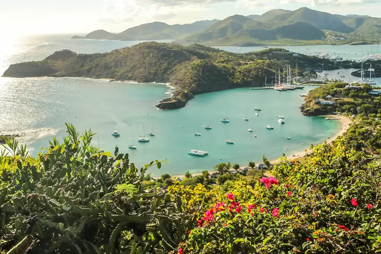 Veleiros em English Harbour, Antígua, com colinas verdes