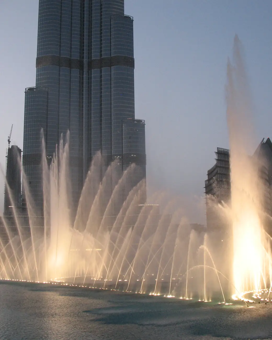 O Burj Khalifa visto de baixo, com os jatos da fonte aos pés