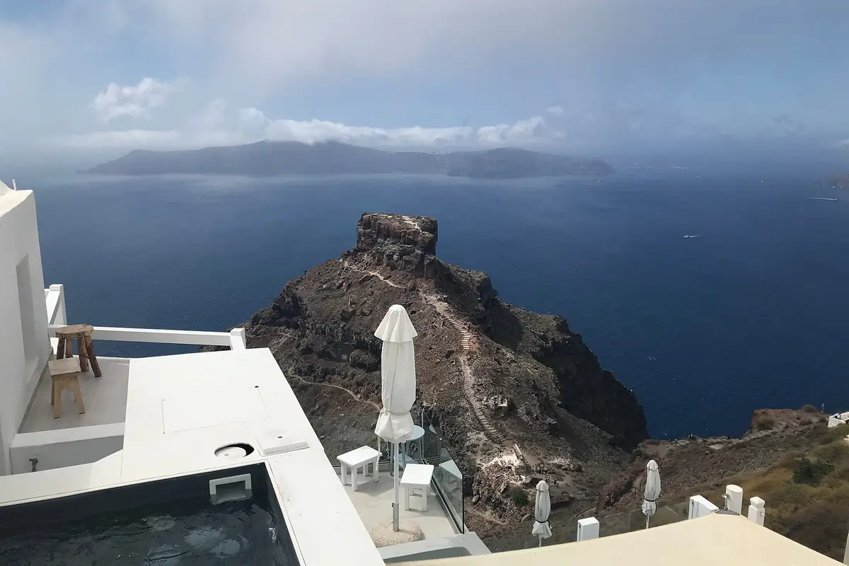 Trilha na borda da caldera entre Fira e Oia, com o rochedo de Skaros