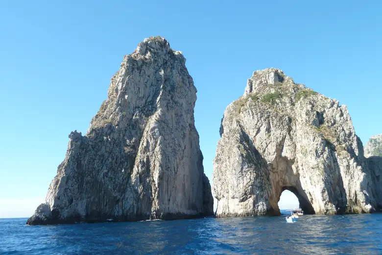 Faraglioni de Capri vistos do mar em dia de céu azul