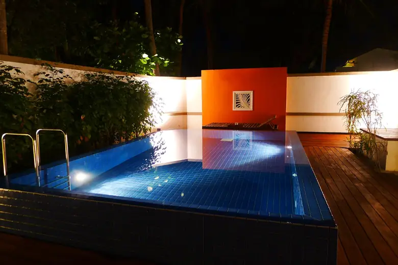 Piscina privativa de uma villa iluminada à noite nas Maldivas