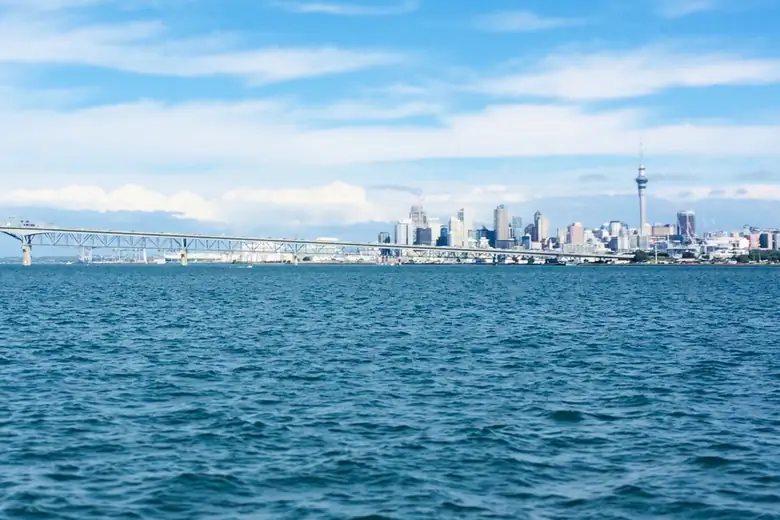 Skyline de Auckland com a Sky Tower e a ponte do porto vistos do mar