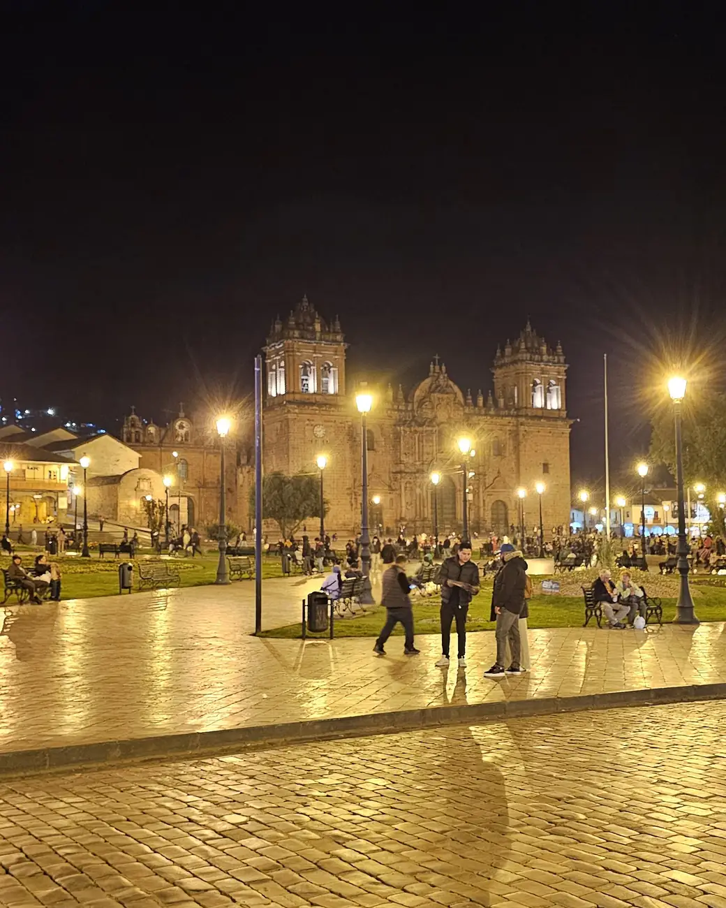 Plaza de Armas de Cusco iluminada ao anoitecer, com a catedral ao fundo