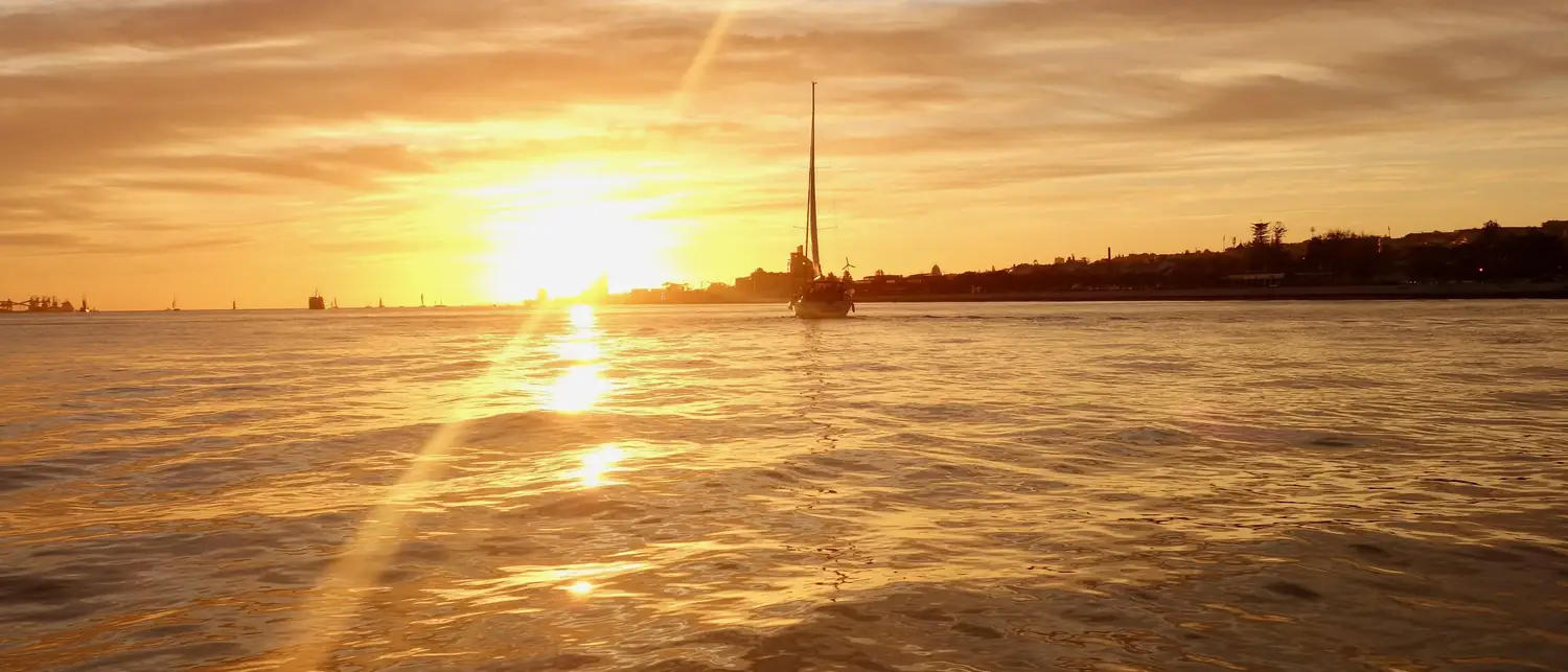 Pôr do sol dourado sobre o rio Tejo em Lisboa