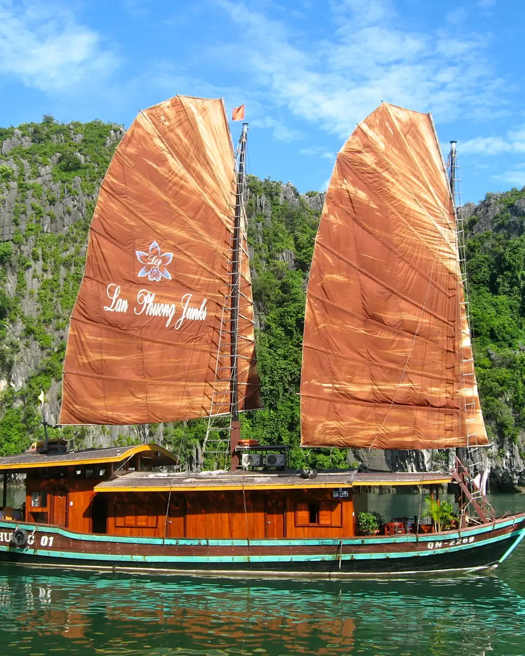 Juncos navegando entre as torres de calcário da Baía de Ha Long