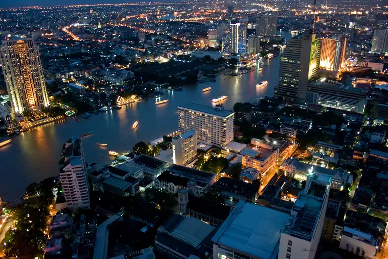 O rio Chao Phraya e Bangkok iluminada vistos do alto, à noite