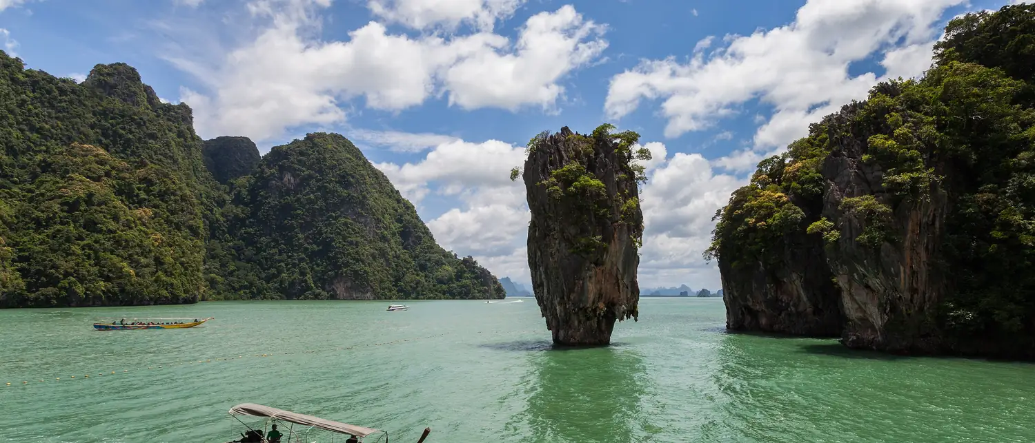 Torres de calcário da Baía de Phang Nga erguendo-se do mar verde-esmeralda