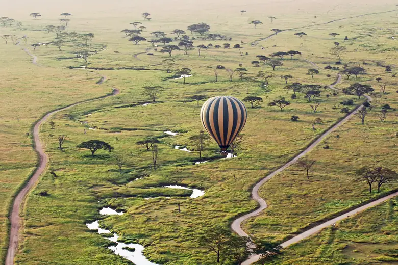 Balão de ar quente sobrevoando a savana do Serengeti ao amanhecer