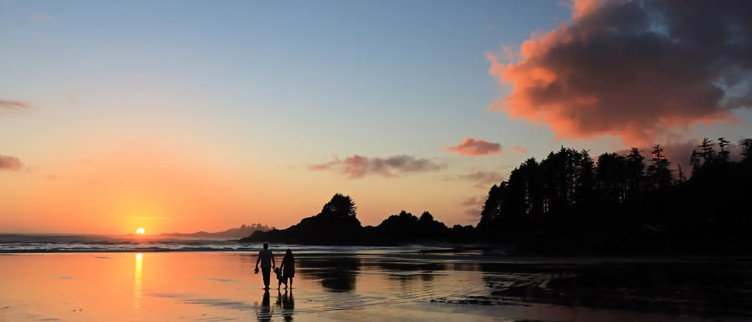 Silhueta de uma família na praia ao entardecer