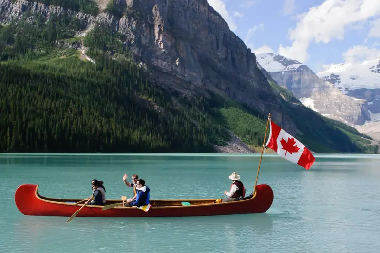 Canoa vermelha com bandeira do Canadá no Lago Louise