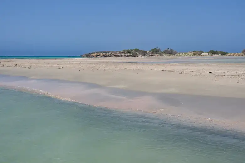 Águas rasas e areia rosada da praia de Elafonissi, em Creta