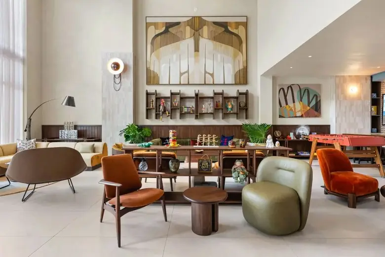 Sala de estar coletiva do Domus, com mesa de sinuca e arte na parede