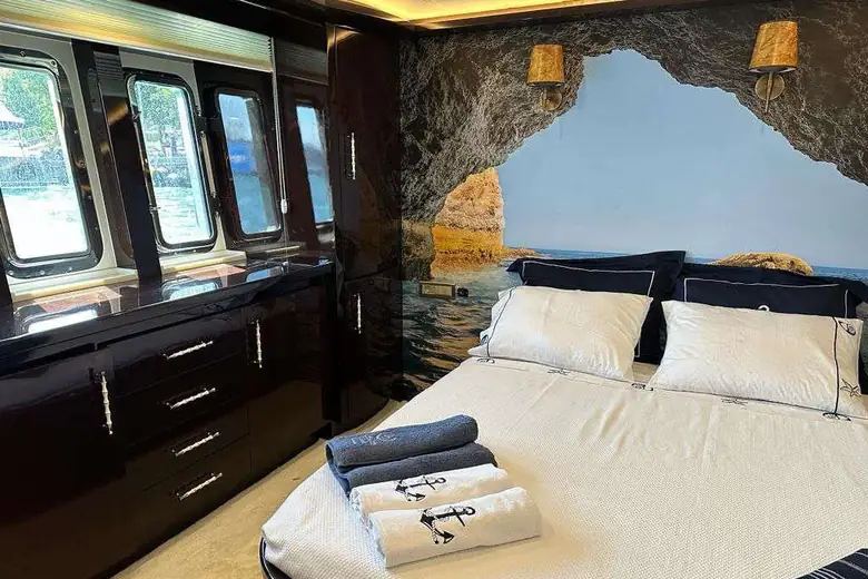Cabine do iate com cama de casal e enxoval náutico