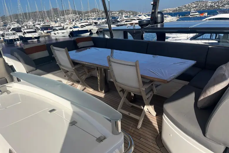 Mesa de jantar no flybridge com marina ao fundo