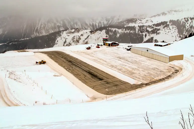 O altiporto de Courchevel na neve, com o hangar ao lado da pista